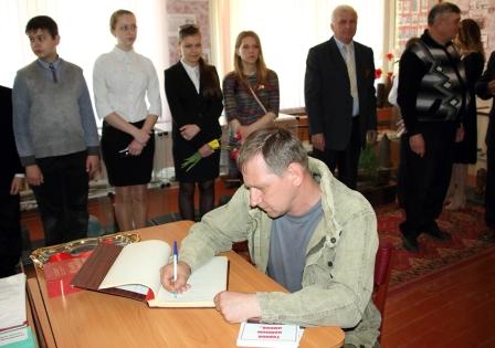 руководитель поисковых отрядов "Дон" Михаил Сегодин оставляет памятную запись в Книге почетных гостей СОШ№2